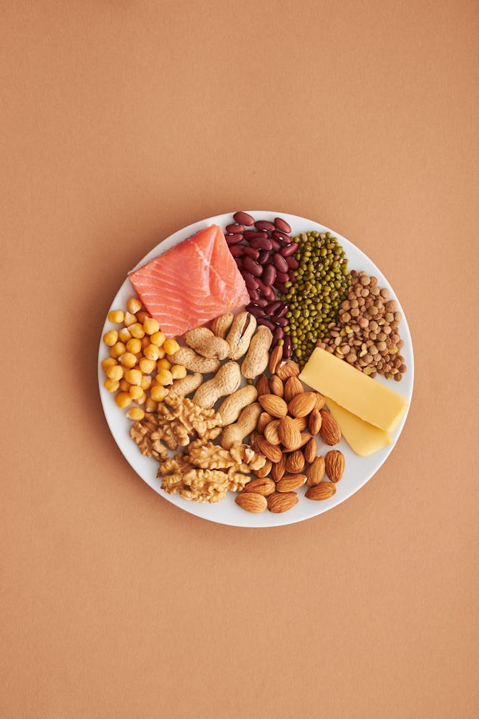 who-we-are Colorful assortment of proteins and legumes on a white plate, perfect for healthy eating inspiration.
