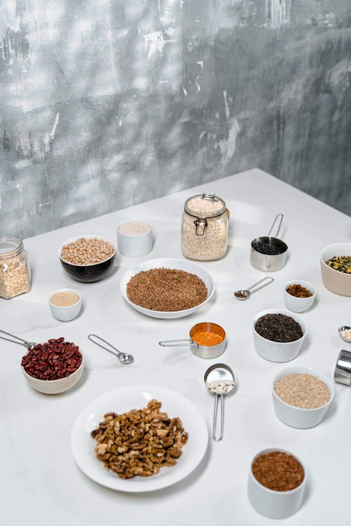 why-choose-us Top view of various organic ingredients including nuts, seeds, and beans arranged on a white table.